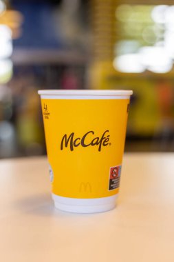Kerpen, Almanya - 9 Ağustos 2025: Sarı McCafe kahve fincanı McDonalds 'da masaya kondu