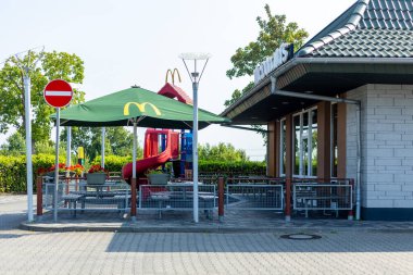 Kerpen, Almanya - 9 Ağustos 2025: Teras ve şemsiyeli McDonalds Restoranı