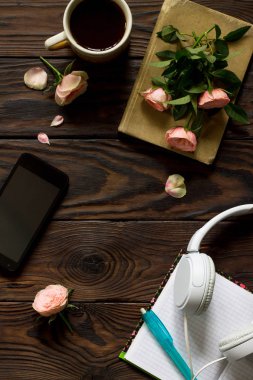 Smartphone, kulaklık, kahve fincanı ahşap bir masa üzerinde. Üst görüntülemek düz yatıyordu arka plan. Kopya alanı