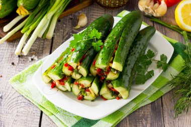 Kore geleneksel yemekleri Kimchi (salatalık). Sebze (tatlı biber, sarımsak, soğan, yeşillik, domates salçası) ahşap mutfak masasında doldurma ile marine edilmiş salatalık.
