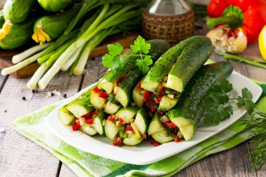Kimchi Koreli turşu salatalık. Sebze (tatlı biber, sarımsak, soğan, yeşillik, domates salçası) ahşap mutfak masasında doldurma ile marine edilmiş salatalık