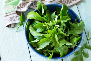 Taze salata roka mutfak ahşap bir masa üzerinde bırakır. Kopya alanı.