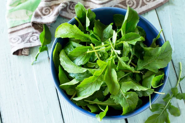 Taze salata roka mutfak ahşap bir masa üzerinde bırakır. Kopya alanı.