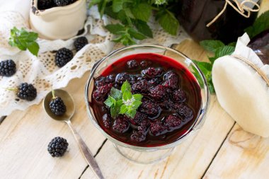 Ev yapımı reçel. Blackberry ve ahşap bir masa üzerine nane ile cam kavanoz. Korunmuş berry. Kopya alanı. 