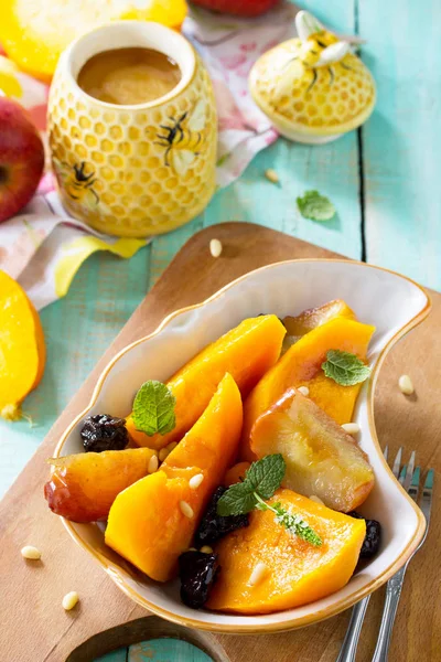 Elma, Erik ve ahşap bir masa üzerinde bir kase içinde baharatlar ile kabak pişmiş. Diyet menüsü. Sağlıklı beslenme kavramı.