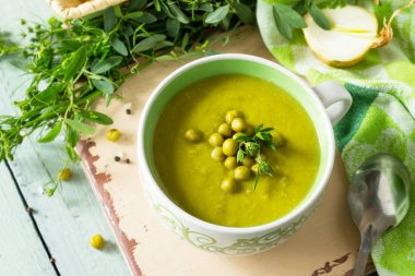 Mutfak ahşap bir masa üzerinde bir kasede yeşil bezelye çorbası püresi. Sağlıklı beslenme kavramı. Diyet menüsü. Kopya alanı.