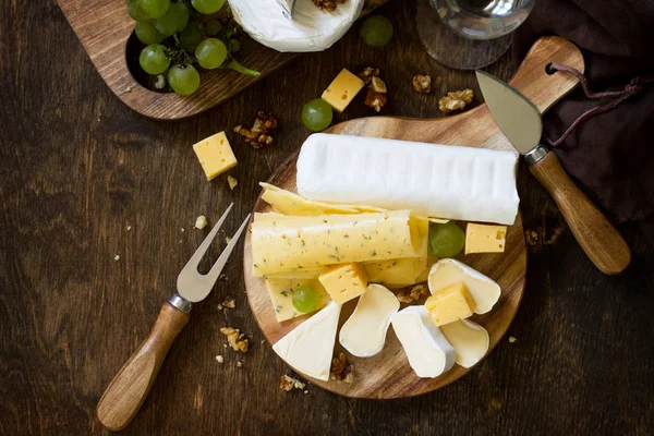 Prato Queijo Sortimento Queijos Uvas Nozes Mesa Madeira Rústica Escura — Fotografia de Stock