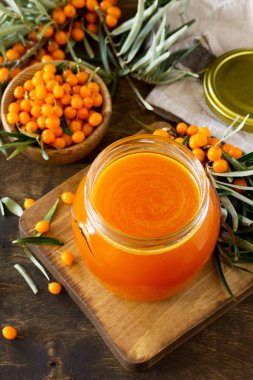 Taze deniz cehri meyveler ve meyve şurubu Deniz topalak ahşap rustik arka plan üzerinde. Kopya alanı