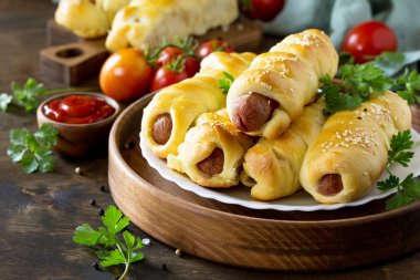 Ahşap masa üzerinde rustik tarzda hamur içinde sosis. 