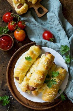 Ahşap masa üzerinde rustik tarzda sosis hamur içinde. Üst görüntülemek düz yatıyordu arka plan. Kopya alanı.