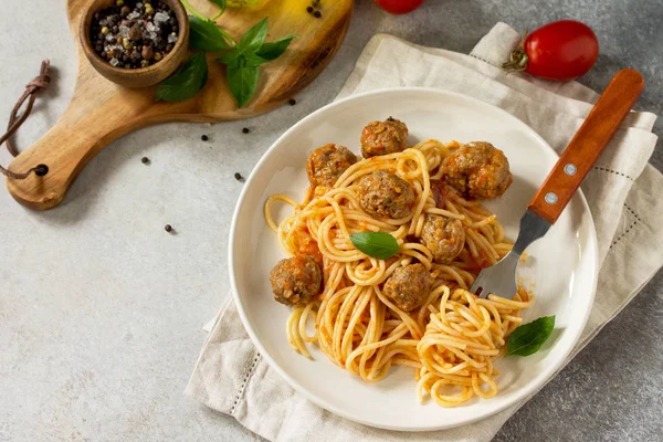 Italian style pasta dinner. Spaghetti with Meatballs with Tomato Sauce on stone or concrete table. Copy space.