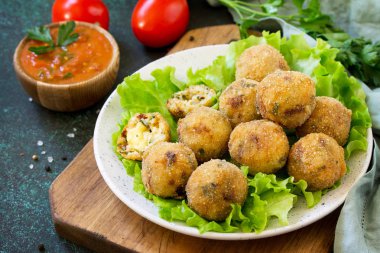 Arancini - traditional Italian Rice Balls with Mozzarella and Sun-dried tomatoes, served with tomato sauce. clipart