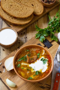 Geleneksel Ukraynalı Rus Pancar çorbası. Borsch, ahşap mutfak masasında kapta ekşi krema çorbası. 