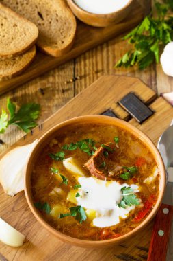 Geleneksel Ukraynalı Rus Pancar çorbası. Borsch, ahşap mutfak masasında kapta ekşi krema çorbası. 