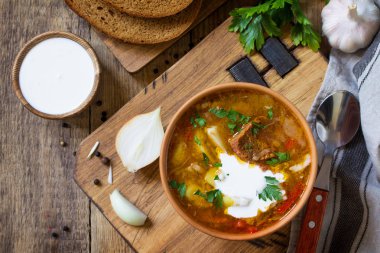 Geleneksel Ukraynalı Rus Pancar çorbası. Borsch Çorbası Ekşi krema kase ahşap mutfak masasında. Üst görüntülemek düz yatıyordu arka plan. Kopya alanı.