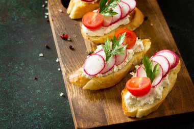 Antipasti aperatifler şarap için ayarlayın. Taş bir tabloda bir rustik ahşap tahta üzerinde brushetta veya Crostini tost baget, peynir, turp ve domates ile servis. Kopya alanı.