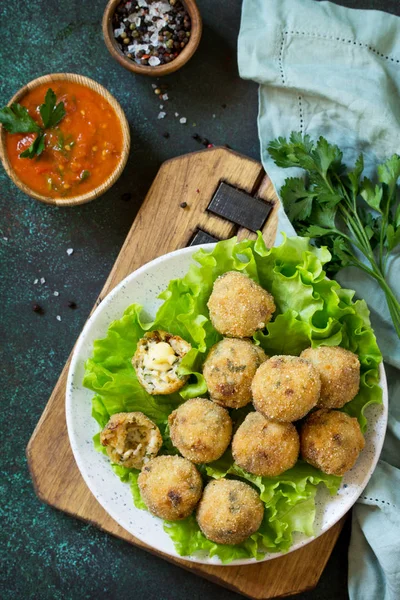 Arancini - traditional Italian Rice Balls with Mozzarella and Sun-dried tomatoes, served with tomato sauce. Top view flat lay background. Copy space.