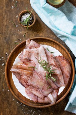 Taze kalamar, çeşitli baharat ve zeytinyağı ahşap bir masa üzerinde. Üst görüntülemek düz yatıyordu arka plan.