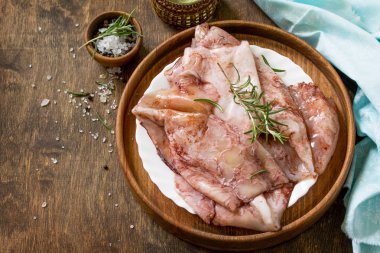 Taze kalamar, çeşitli baharat ve zeytinyağı ahşap bir masa üzerinde. Kopya alanı