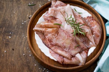 Taze kalamar, çeşitli baharat ve zeytinyağı ahşap bir masa üzerinde. Kopya alanı