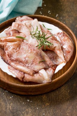 Taze kalamar, çeşitli baharat ve zeytinyağı ahşap bir masa üzerinde