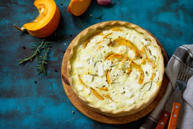 Klasik Quiche Lorraine pasta kabak ve mavi beton veya taş tablo üzerinde beyaz peynir ile. Üst görüntülemek düz yatıyordu arka plan. Kopya alanı.