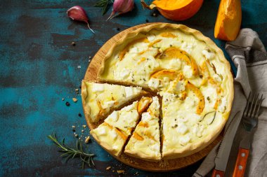 Klasik Quiche Lorraine pasta kabak ve mavi beton veya taş tablo üzerinde beyaz peynir ile. Üst görüntülemek düz yatıyordu arka plan. Kopya alanı.