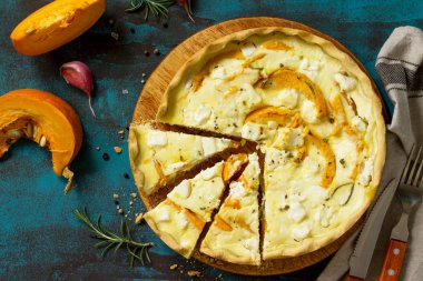Klasik Quiche Lorraine pasta kabak ve mavi beton veya taş tablo üzerinde beyaz peynir ile. Üst görüntülemek düz yatıyordu arka plan.