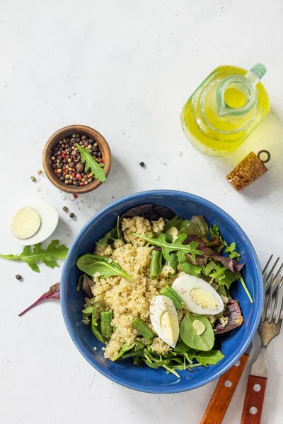 Diet menu, Vegan food. Healthy salad with quinoa, arugula, green Beans and Eggs on a white stone table. Top view flat lay background. Copy space.