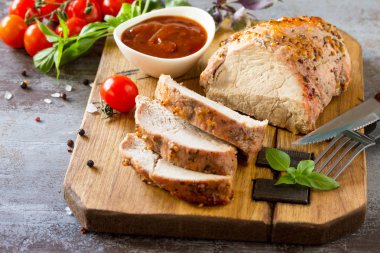 Pişmiş et. Karanlık bir taş masada ketçap ile Kızartma domuz eti et tatlım-hardal sır ile servis