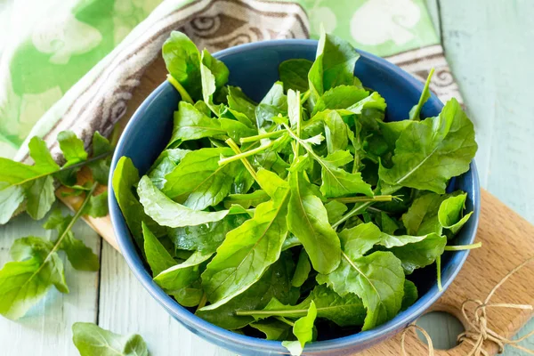 Taze salata arugula rustik bir mutfak ahşap masa üzerinde bırakır.