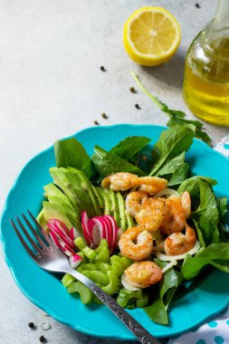 Izgara karides, rucola, turp, avokado, kereviz ve salata sosu ışık arduvaz arka plan üzerinde sağlıklı sebze salatası. Diyet menüsü. Kopya alanı.