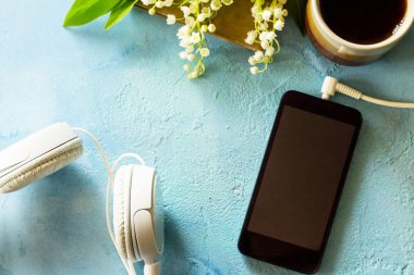 Bahar. Smartphone, vadideki zambak, kulaklık ve cof