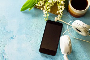 Bahar. Smartphone, vadideki zambak, kulaklık ve cof