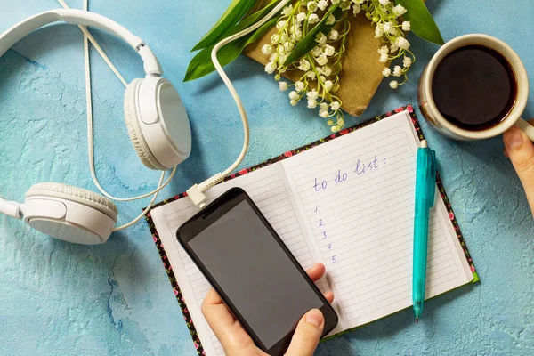 stock image Smartphone in female hands and writing in notebook, lilies of th