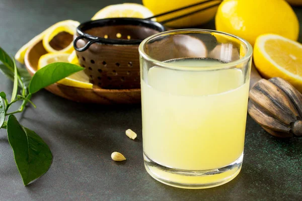 Kaltgetränk mit frisch gepresstem Zitronensaft und frischen Zitronen auf — Stockfoto