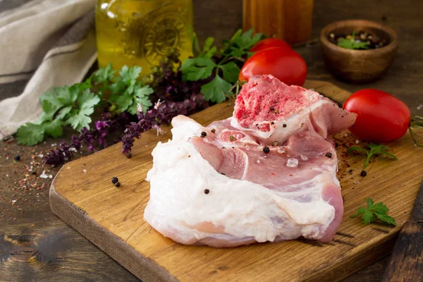 Fresh raw meat. Raw pork meat steak with olive oil, tomatoes and