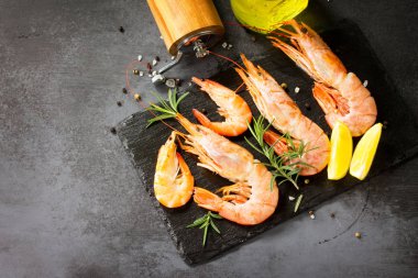 Deniz ürünleri. Bir kayrak tahtasında baharat ve limon ile çiğ karides. Ücret -siz