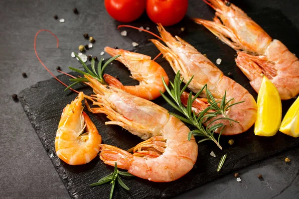 Frutos do mar. Camarões crus com tempero, tomates e limão em uma ardósia b — Fotografia de Stock