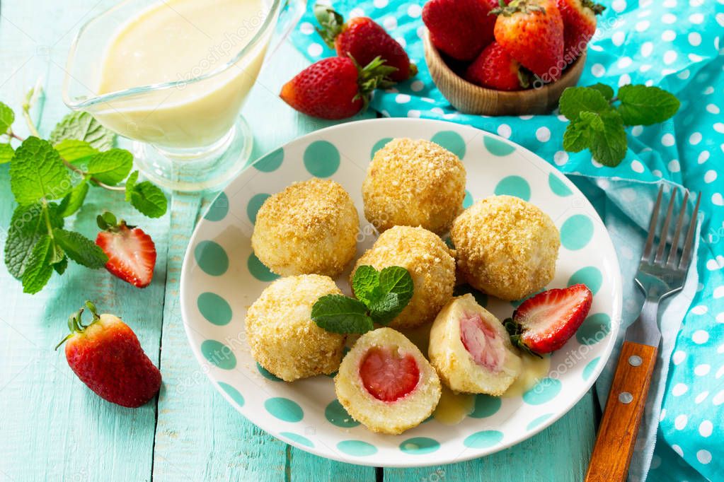 Cottage cheese dumplings with fresh strawberry, served with sour