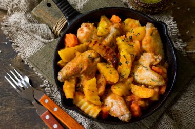 Rustik ahşap masada karamelize armut ile tavuk güveç. 