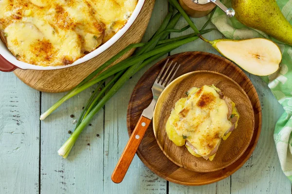 Aardappelgratin met peer, raclette kaas en spek op rustiek wo — Stockfoto