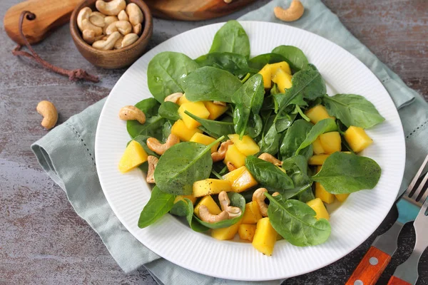 Diätmenü, veganes Essen. gesunder Salat mit Spinat, Mango, Pekannuss — Stockfoto