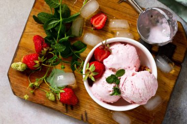 Açık bir taş veya kayrak sekmesinde beyaz kase çilekli dondurma