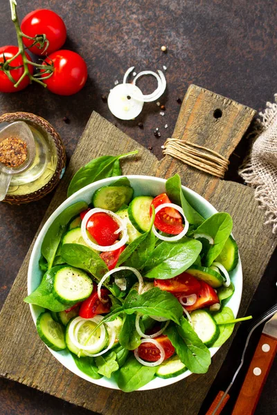 Витаминные закуски. Салат со свежими овощами и шпинатом в темноте — стоковое фото