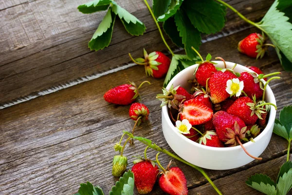 Fresh strawberries in a bowl on a wooden rustic table. — Stock Photo, Image