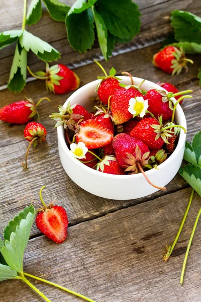 Verse aardbeien in een kom op een houten rustieke tafel. — Stockfoto