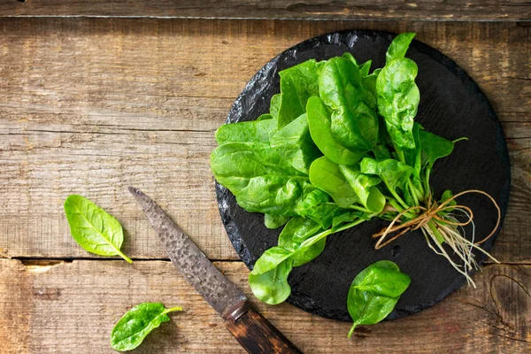 Frische Salatspinatblätter auf dem hölzernen Küchentisch. Kostenloser Wellnessbereich — Stockfoto