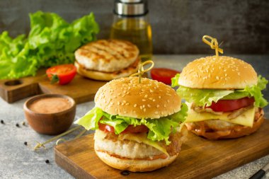 Tavuk eti pirzisi ile iki ev yapımı burger, eritilmiş peynir,