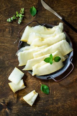 Taze kavun rustik ahşap masada parçalara dilimlenmiş. Üstte görünüm f